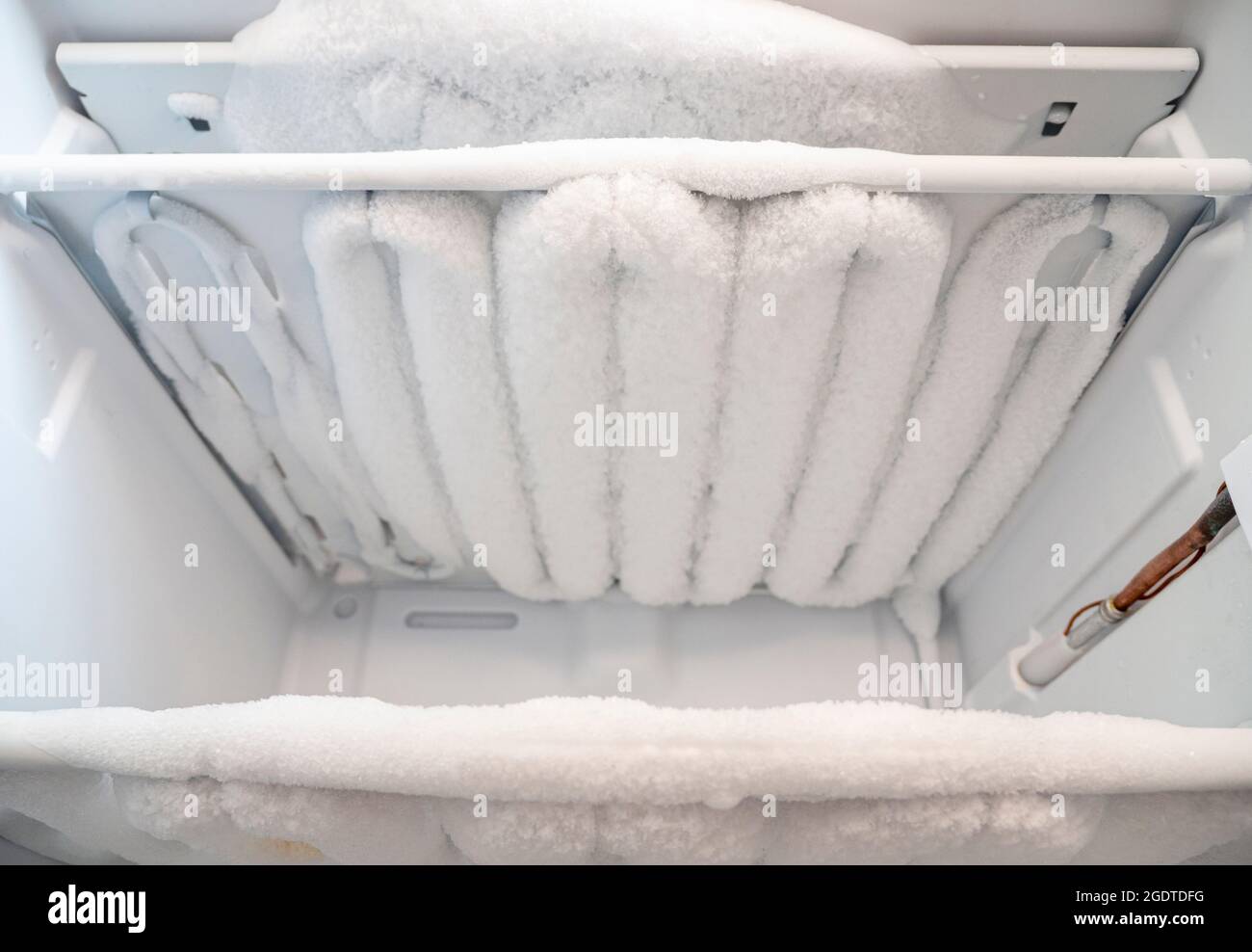 Gros plan du congélateur ouvert avec de la glace et de la neige
