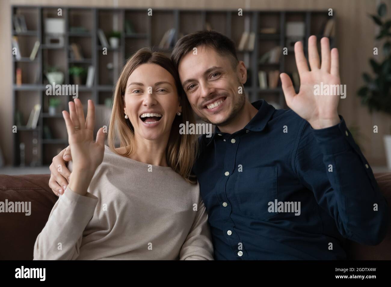Accueil de couple en famille commence la visioconférence sur le canapé Banque D'Images