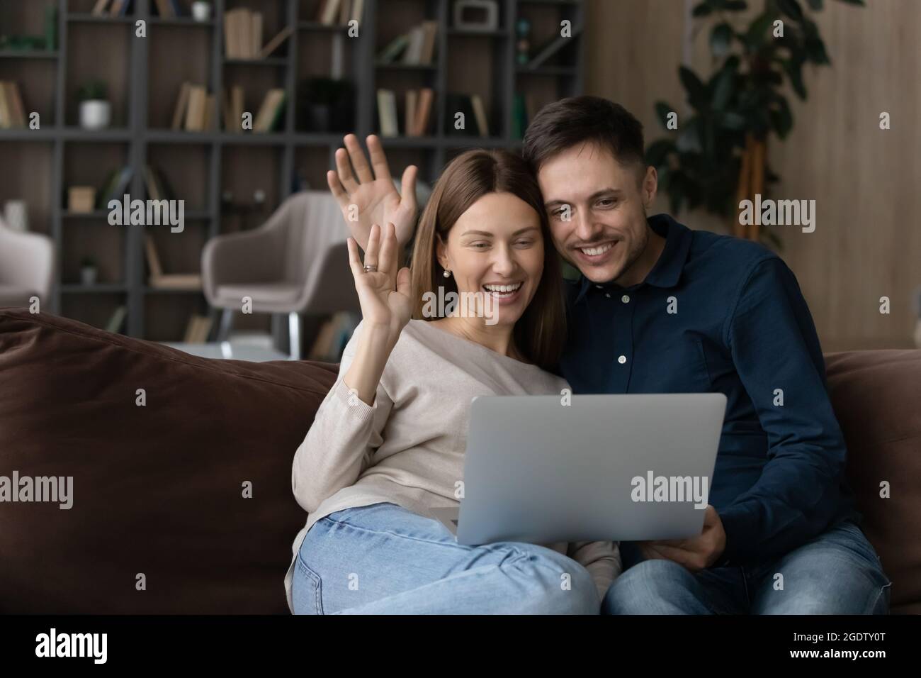 Couple saluant famille commencer la conversation par appel vidéo sur ordinateur portable Banque D'Images