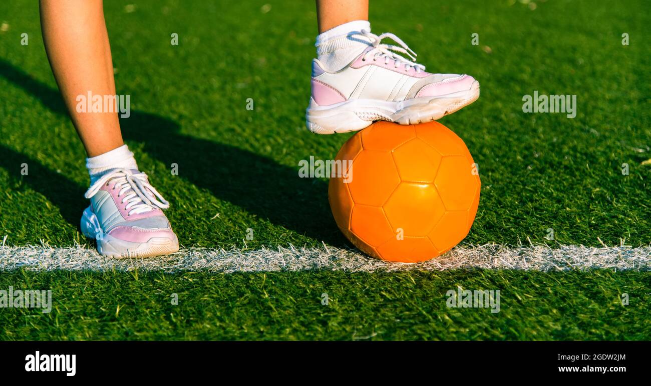 Fille joueur de football. Gros plan sur le pied de la jeune fille sur le ballon pour le jeu. Banque D'Images