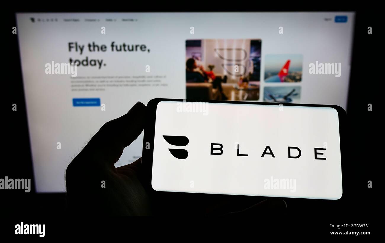 Personne tenant un smartphone avec le logo de la société de transport américaine BLADE Urban Air Mobility Inc. À l'écran devant le site Web. Mise au point sur l'affichage du téléphone. Banque D'Images
