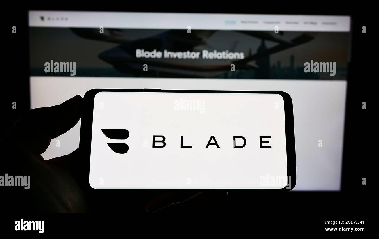 Personne tenant un téléphone portable avec le logo de la société de transport américaine BLADE Urban Air Mobility Inc. À l'écran en face de la page Web. Mise au point sur l'affichage du téléphone. Banque D'Images