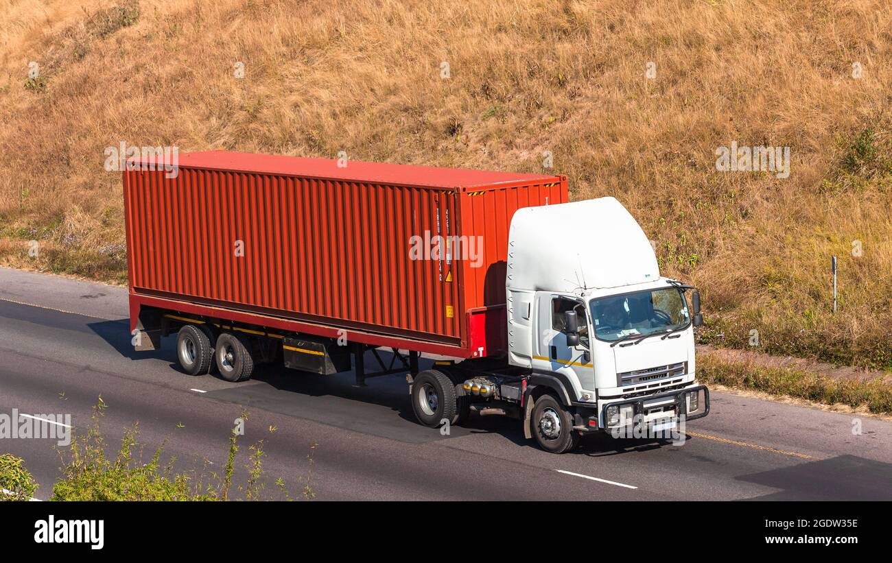 Camion avec conteneur de fret d'expédition rouge conducteur de véhicule industriel conduite sur route photo en hauteur. Banque D'Images