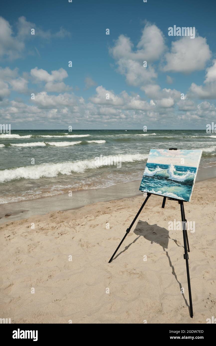un chevalet avec une photo se dresse sur la mer sans personnes par temps ensoleillé Banque D'Images