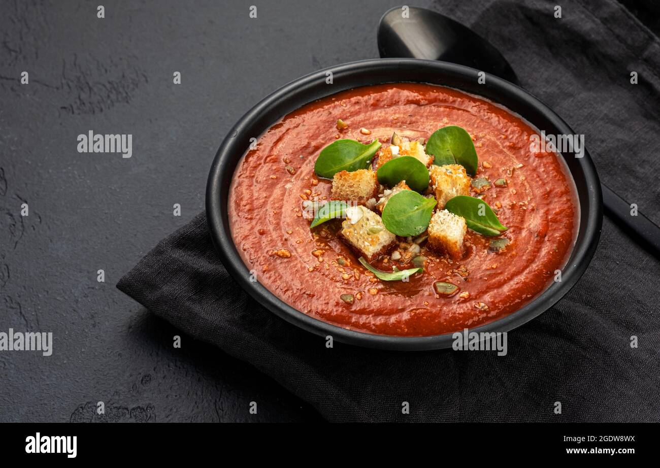 Bol de soupe aux tomates sur fond noir Banque D'Images