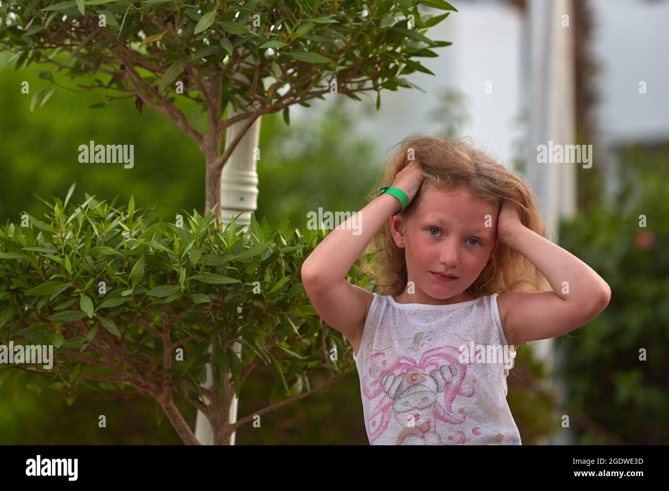 portrait de la petite fille sur fond de verdure. Fille posant sur fond de verdure d'été. Portrait de petite fille Banque D'Images