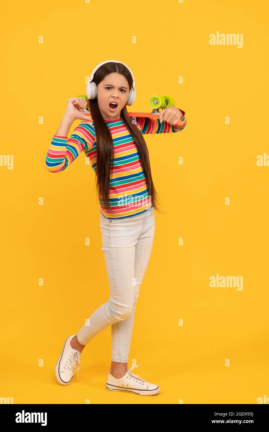malheureux enfant skateboarder ecouter de la musique dans les écouteurs avec penny board skateboard, hippster Banque D'Images