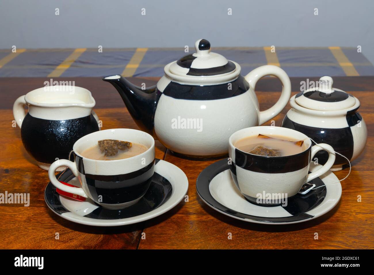 Thé au lait servi dans un ensemble de thé en céramique avec design et sachets de thé à l'intérieur Banque D'Images