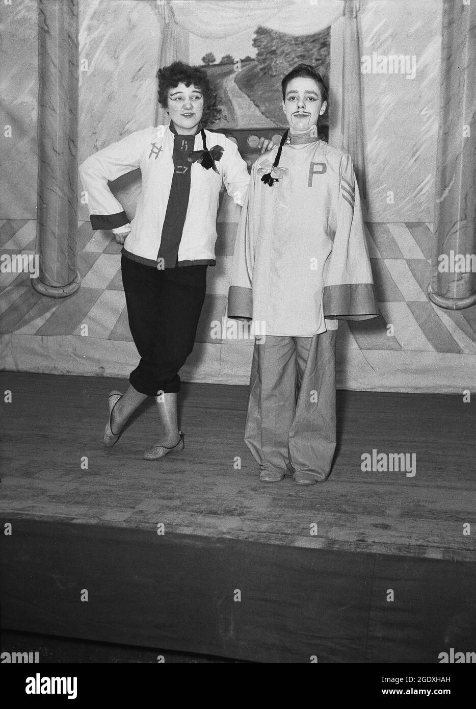 1957, historique, deux artistes dans leurs costumes apparaissant dans la pantomine Aladdin, basé sur l'histoire populaire du Moyen-Orient sur une jeunesse pauvre qui vient en possession d'une lampe magique, debout sur la scène pour leur photo, Angleterre, Royaume-Uni. Banque D'Images