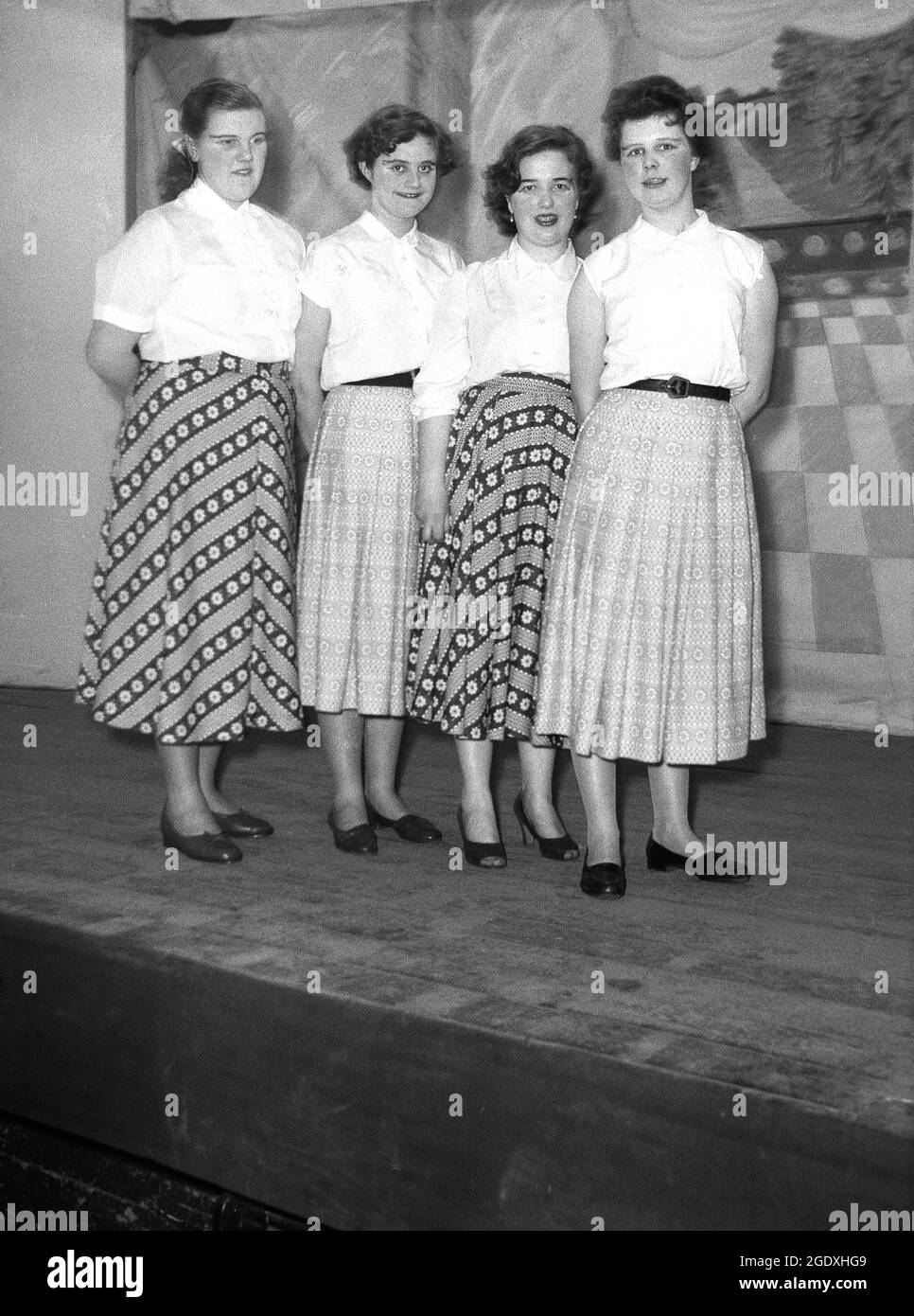1957, historique, quatre femmes interprètes en chemisiers et longues jupes apparaissant dans la pantomine Aladdin stand sur la scène pour leur photo, Angleterre, Royaume-Uni. Banque D'Images