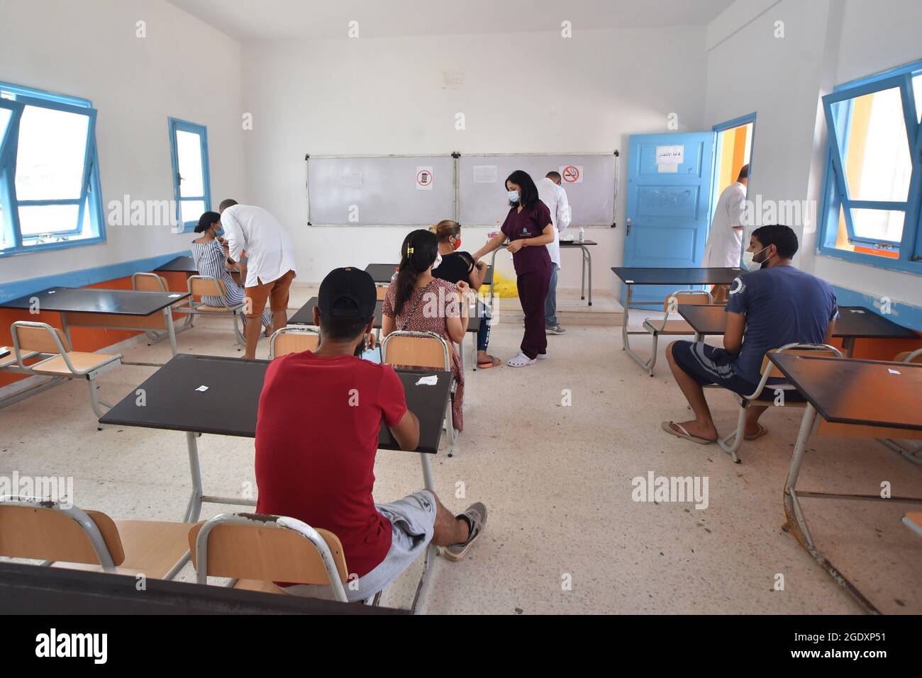 Les travailleurs de la santé administrent des doses du vaccin Moderna COVID-19 à des personnes dans un centre d'inoculation dans un bâtiment d'école secondaire de la capitale Tunis.le directeur général de la santé tunisien Faycel Ben Salah a déclaré que près d'un million de personnes seront appelées à la 2e journée de vaccination intensive du coronavirus, ciblant les groupes d'âge de 18-39 ans. Banque D'Images