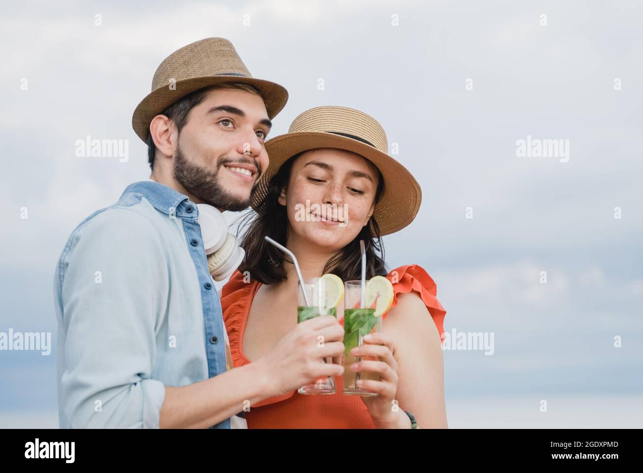 Jeunes couples d'amoureux qui s'amusent à boire des cocktails à la première date au bar-restaurant avec le ciel sur fond - Focus sur le visage de fille Banque D'Images