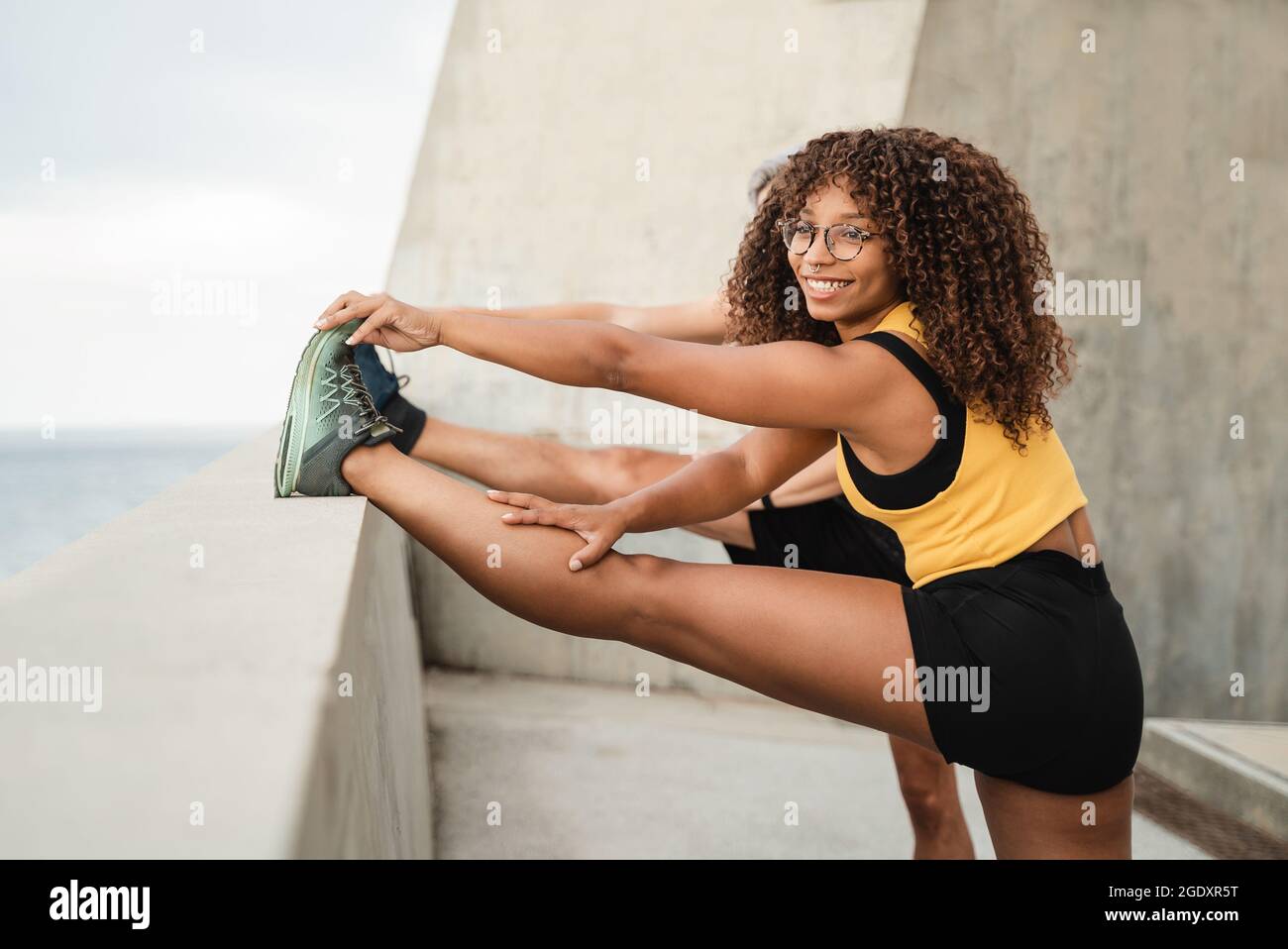 Divers joggeurs d'entraînement faire la routine d'entraînement d'entraînement avant la séance de course à l'extérieur dans le parc de la ville - Focus sur le visage de fille afro-américaine Banque D'Images