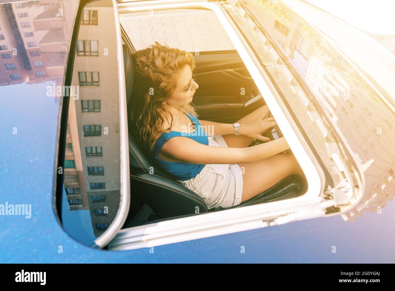 Vue de dessus depuis le toit ouvrant d'une jeune femme magnifique assise sur le siège de voiture et conduire prudemment. Photo de haute qualité Banque D'Images