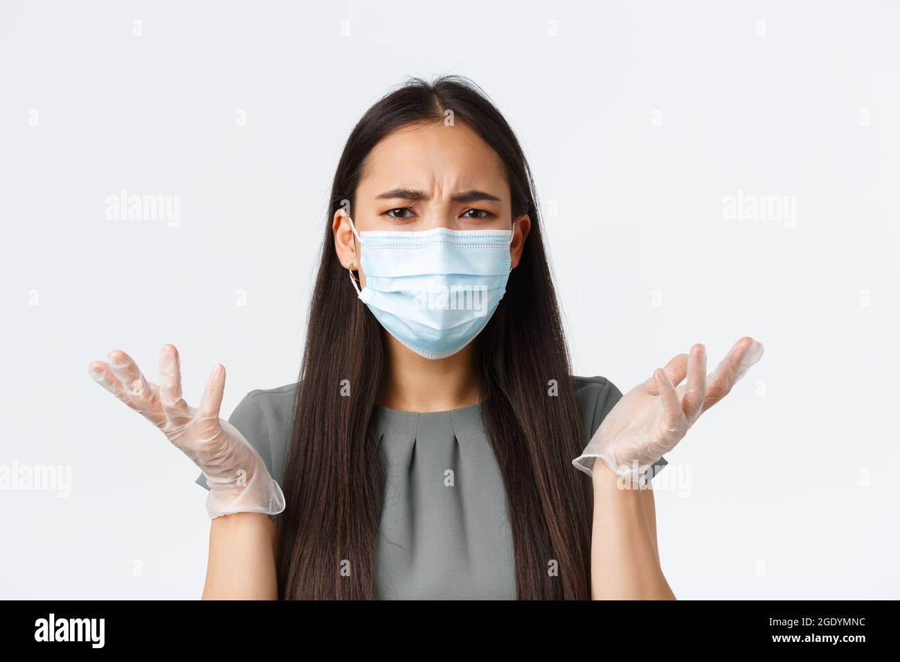 Les propriétaires de petites entreprises, covid-19, prévention des virus concept de mesures. Frustrée et irritée femme asiatique dans le masque médical et les gants, haussant Banque D'Images