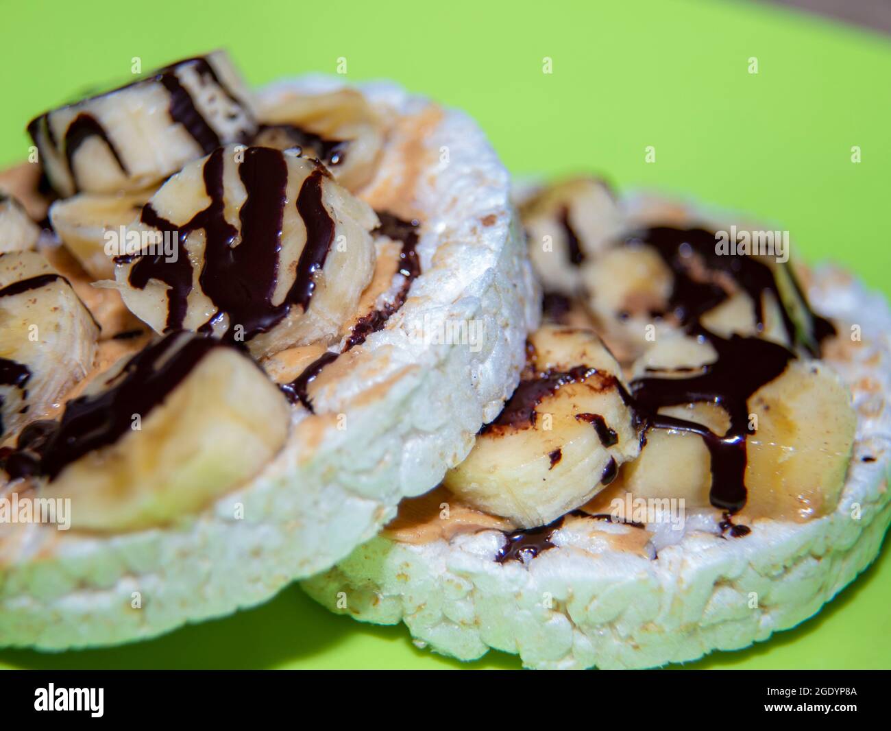 Gâteaux de riz avec de la banane et de la bruine de chocolat noir Banque D'Images