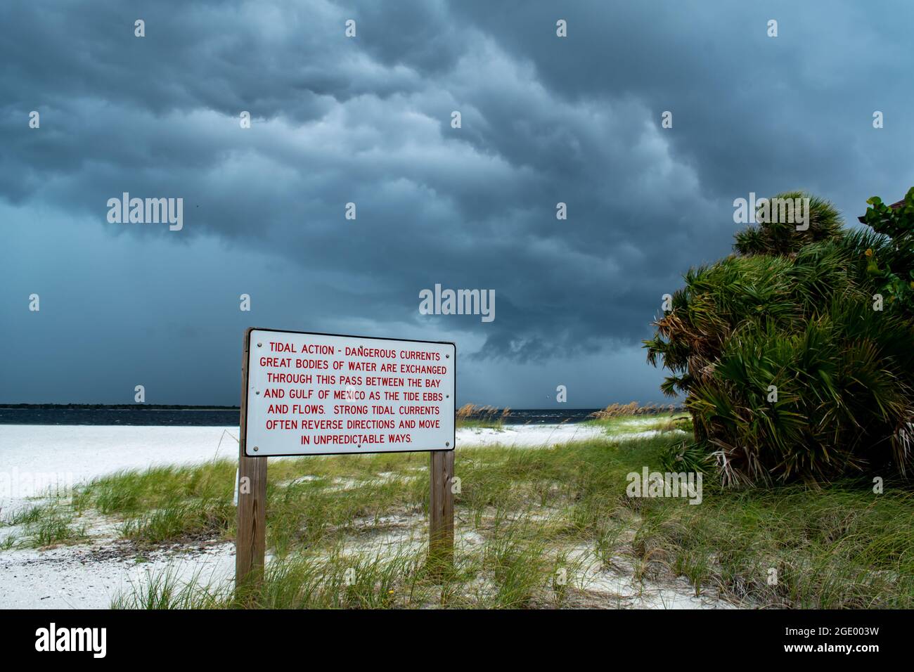 Panneaux d'avertissement sur la plage avec des drapeaux rouges ; le phare et le musée de Port Boca Grande, l'île Gasparilla comme une tempête tropicale avec des nuages noirs se rassemblent Banque D'Images Panneaux d'avertissement sur la plage avec des drapeaux rouges ; le phare et le musée de Port Boca Grande, l'île Gasparilla comme une tempête tropicale avec des nuages noirs se rassemblent Banque D'Images