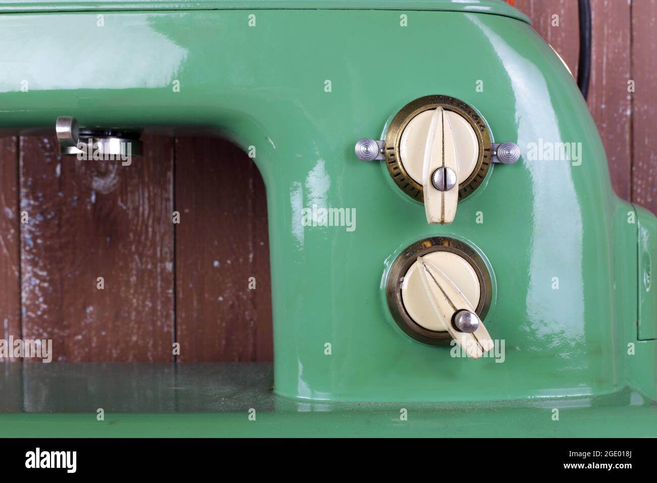 Appareils ménagers - gros plan fragment vieux rétro vert machine à coudre arrière-plan en bois Banque D'Images
