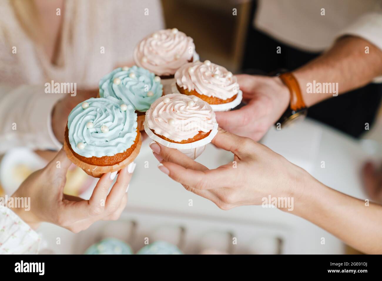 Des amis blancs tenant des muffins pendant la fête de genre révèlent la fête à l'intérieur Banque D'Images