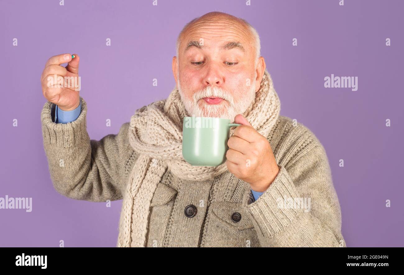 Homme malade avec thé de guérison et pilules pharmaceutiques. Un homme malade prend une pilule. Médecine. Traitement. Banque D'Images