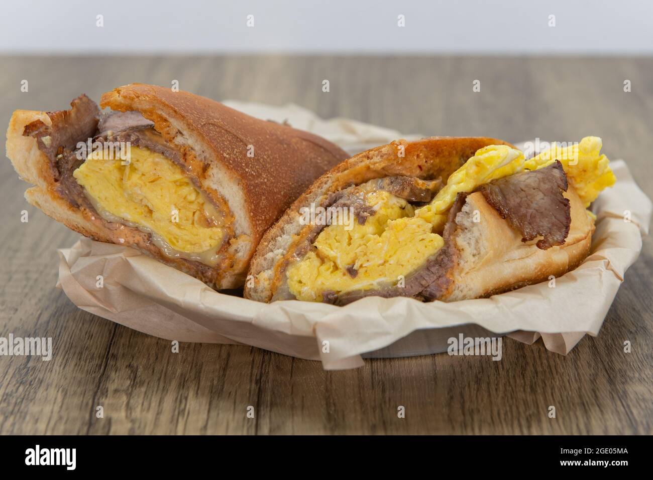 Sandwich au steak et aux œufs brouillés chargé de toutes les bonnes fixations pour combler tout