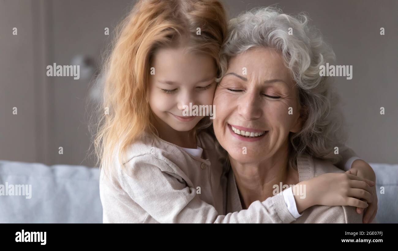 Petite petite petite-fille embrasse la vieille grand-mère montrant l'amour Banque D'Images