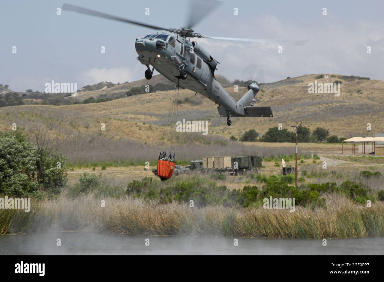 U S Navy MH60S descend pour remplir Bambi Bucket d'un lac sur MCB Camp Pendleton, Californie Banque D'Images