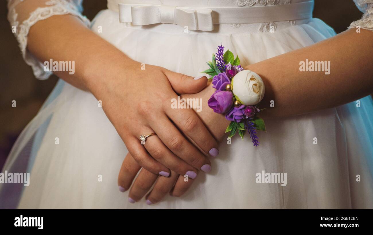Les mains de la mariée avec la boutonnière décorative sur la robe de mariage  gros plan Photo Stock - Alamy