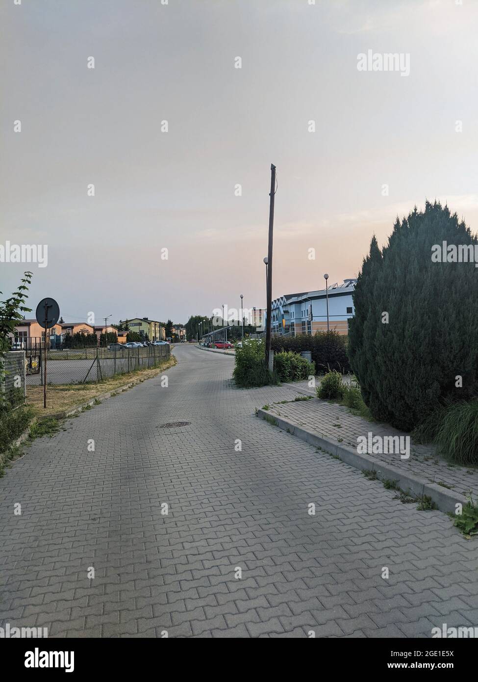 Chaussée en pierre de brique avec des bâtiments et des arbres lors d'une belle journée chaude Banque D'Images