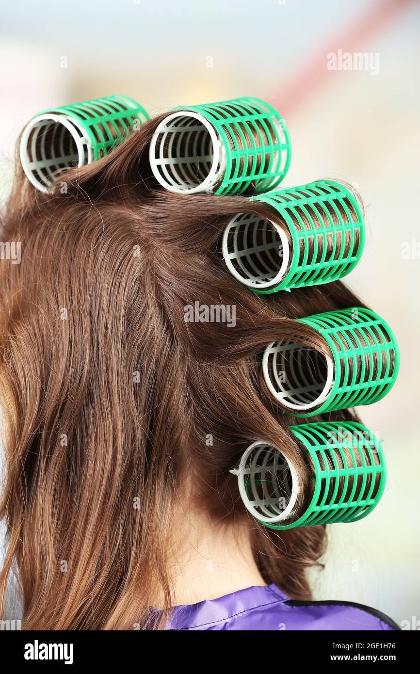 Cheveux longs pour femmes lors de la coiffure avec boucleur, gros plan, sur  fond clair Photo Stock - Alamy