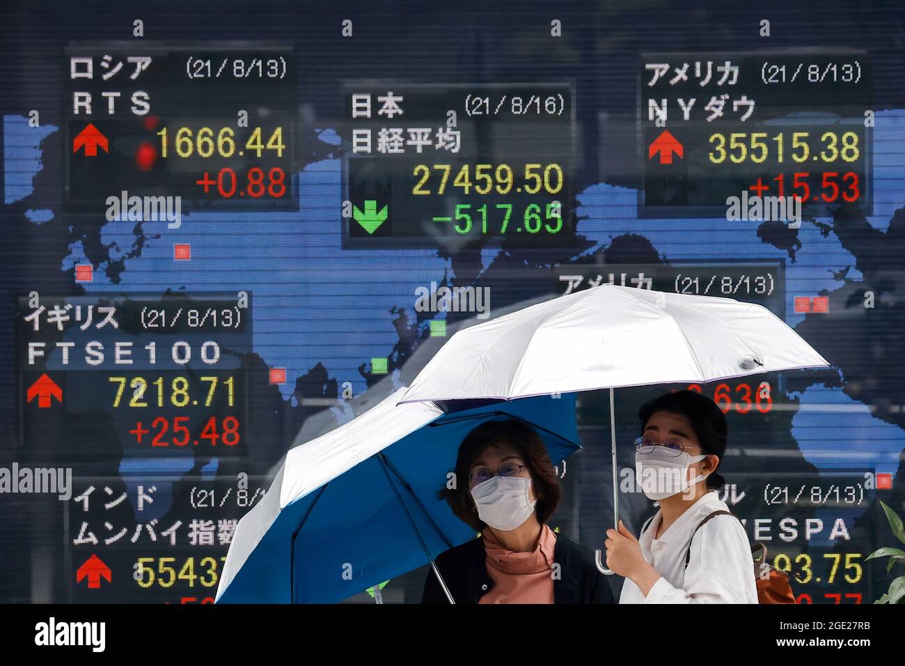 Tokyo, Japon. 16 août 2021. Les femmes tenant un parapluie marche devant un tableau électrique montrant Nikkei index a courtage à Tokyo. (Photo de James Matsumoto/SOPA Images/Sipa USA) crédit: SIPA USA/Alay Live News Banque D'Images