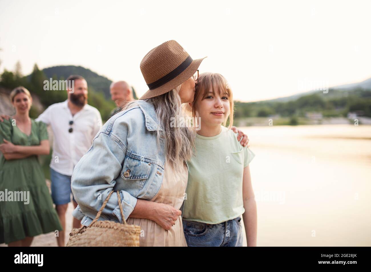 Bonne famille multigénération pendant les vacances d'été, à pied au bord du lac. Banque D'Images