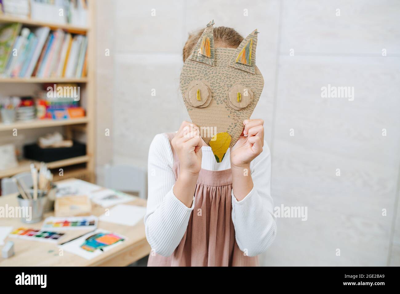 Petite fille holng carton fait main renard masque sur son visage Banque D'Images