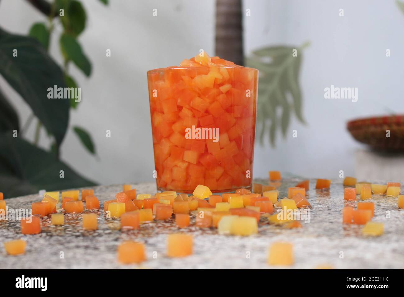 papaye aux fruits tropicaux rouges et jaunes coupée en dés carrés dans l'album nourriture et boissons, détente d'été, dans le coin jardin sur la table en pierre Banque D'Images