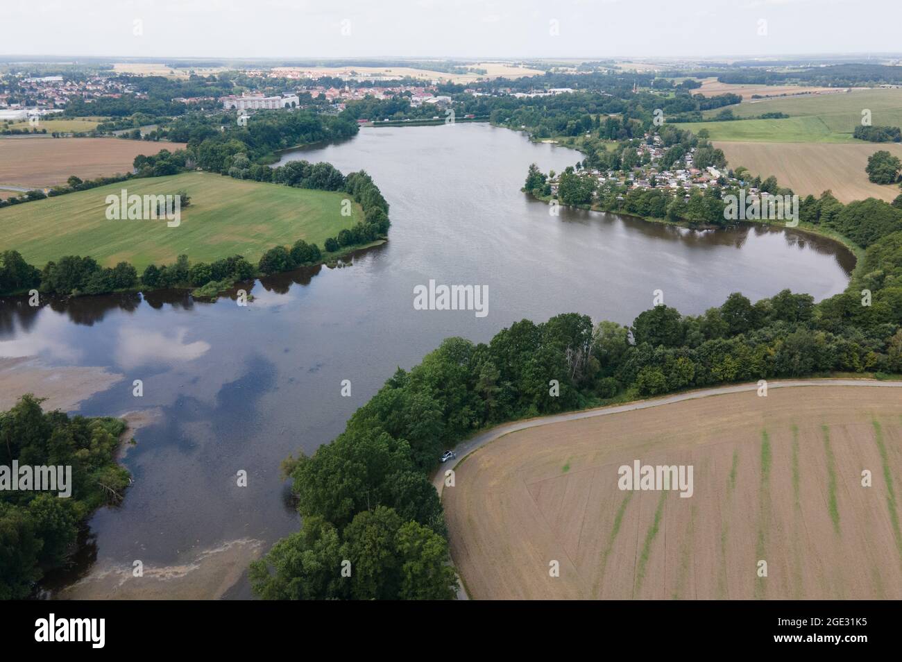 Radeburg, Allemagne. 16 août 2021. Un sentier de campagne entoure le bassin d'eau du barrage de Radeburg. Le barrage dans le comté de Meißen doit être débarrassé des sédiments d'ici octobre 2022. Les sédiments doivent être éliminés, sinon le barrage ne fonctionnera pas correctement. (Vue aérienne avec drone) Credit: Sebastian Kahnert/dpa-Zentralbild/ZB/dpa/Alamy Live News Banque D'Images