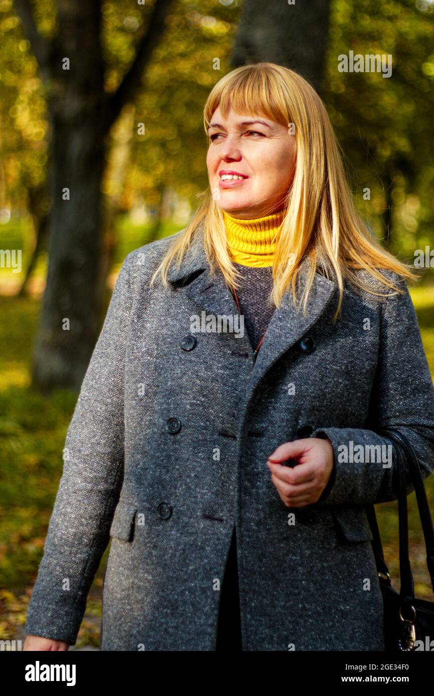 Portrait de mode de style de vie en plein air de jolies femmes âgées heureuses marchant sur le parc d'automne. Porter un élégant manteau gris. Souriant, en appréciant l'autum Banque D'Images