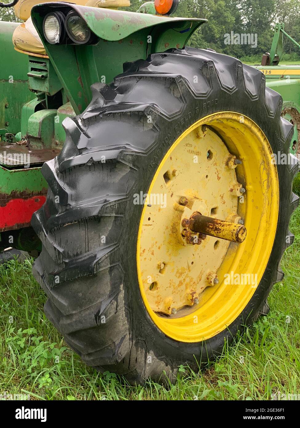 tracteur et presse à balles dans le champ par une journée nuageux Banque D'Images