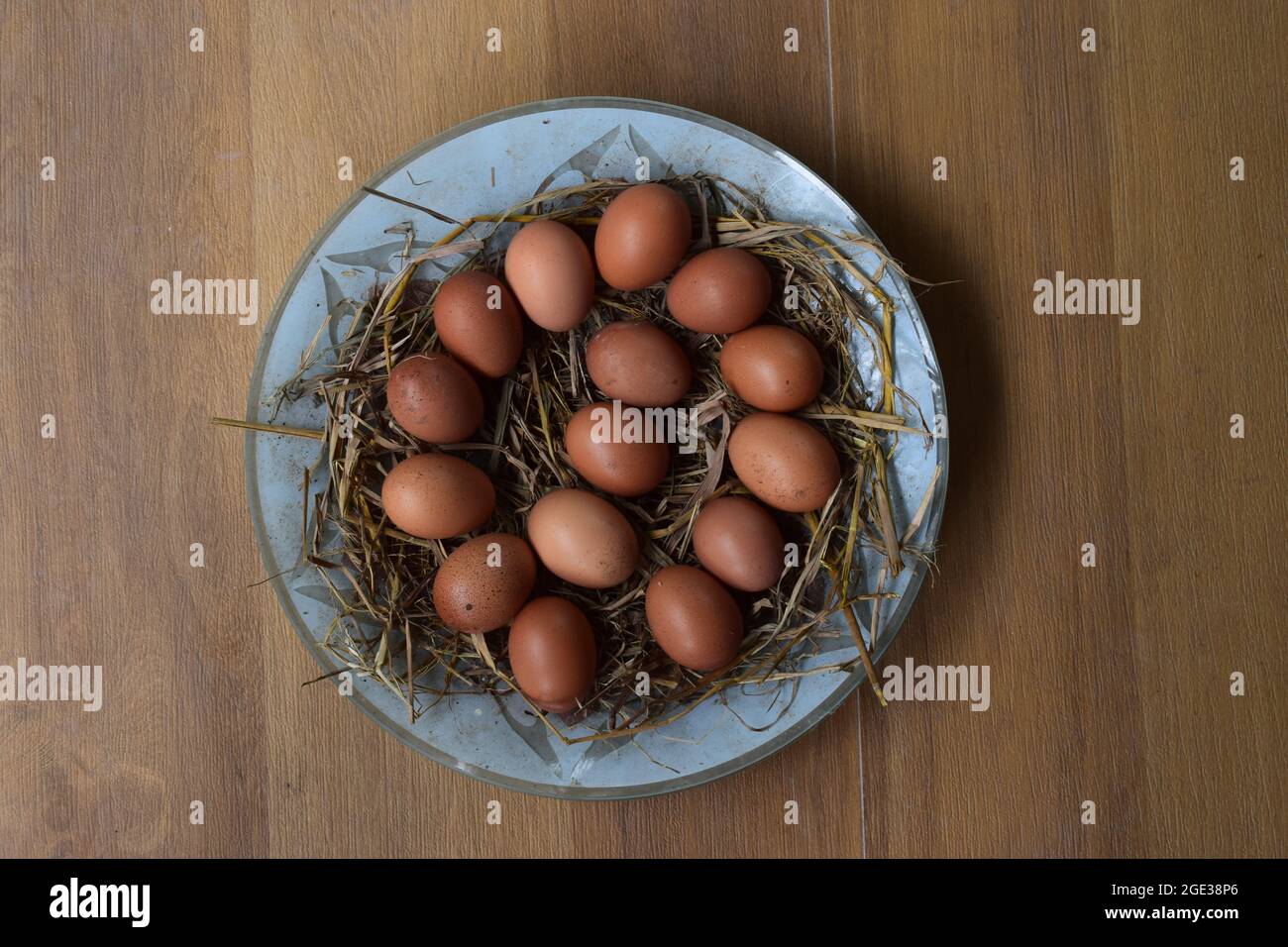 Œufs frais sur l'assiette, collecte d'œufs frais avec couche d'aubergines et de paille sur l'assiette en fond de tuile, grappe d'œufs chauds crus, grappe d'œufs Banque D'Images