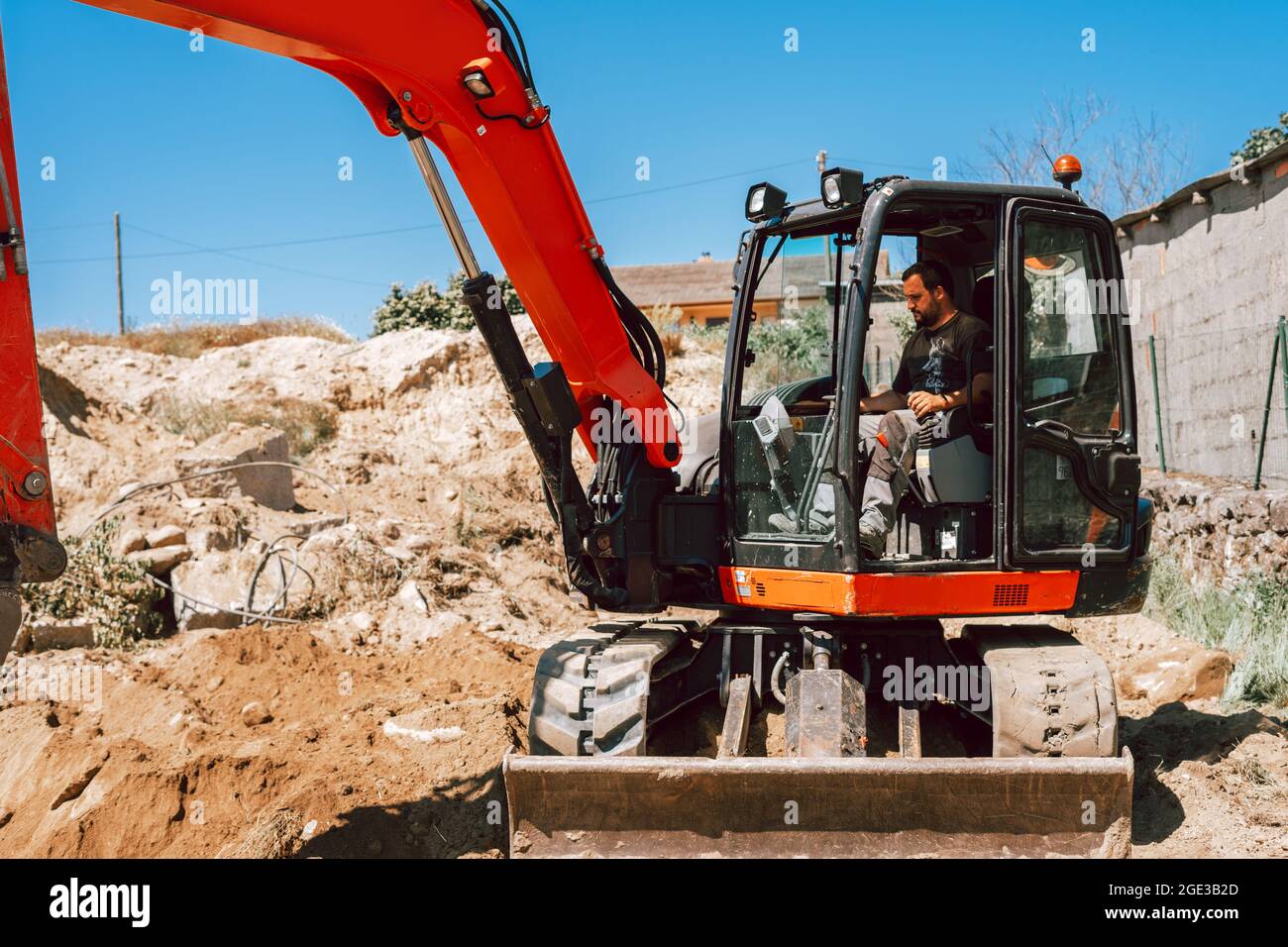 Homme conduisant une pelle hydraulique sur un chantier de construction. Banque D'Images