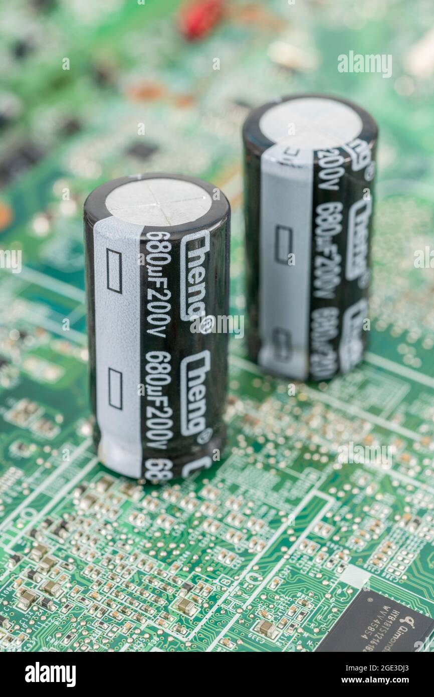 Gros plan de 2 condensateurs électrolytiques aluminium de grande taille sur ci. Affichage des spécifications des pièces et des marques de polarité. Marque Cheng. Banque D'Images