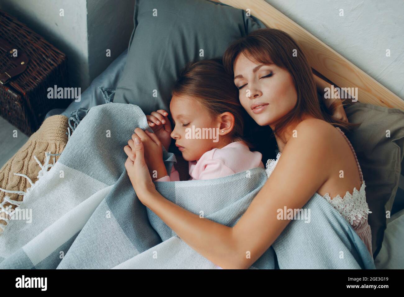 La mère dorment en s'embrassant avec sa petite fille. Famille parent unique jour de mère et bonne nuit concept. Banque D'Images
