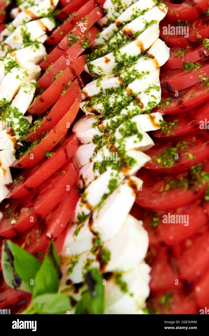 Fond de salade Caprese. Beaucoup de tomates tranchées et de fromage mozzarella recouverts de sauce pesto. Photo de concept de mode de vie sain. La cuisine est magnifique Banque D'Images