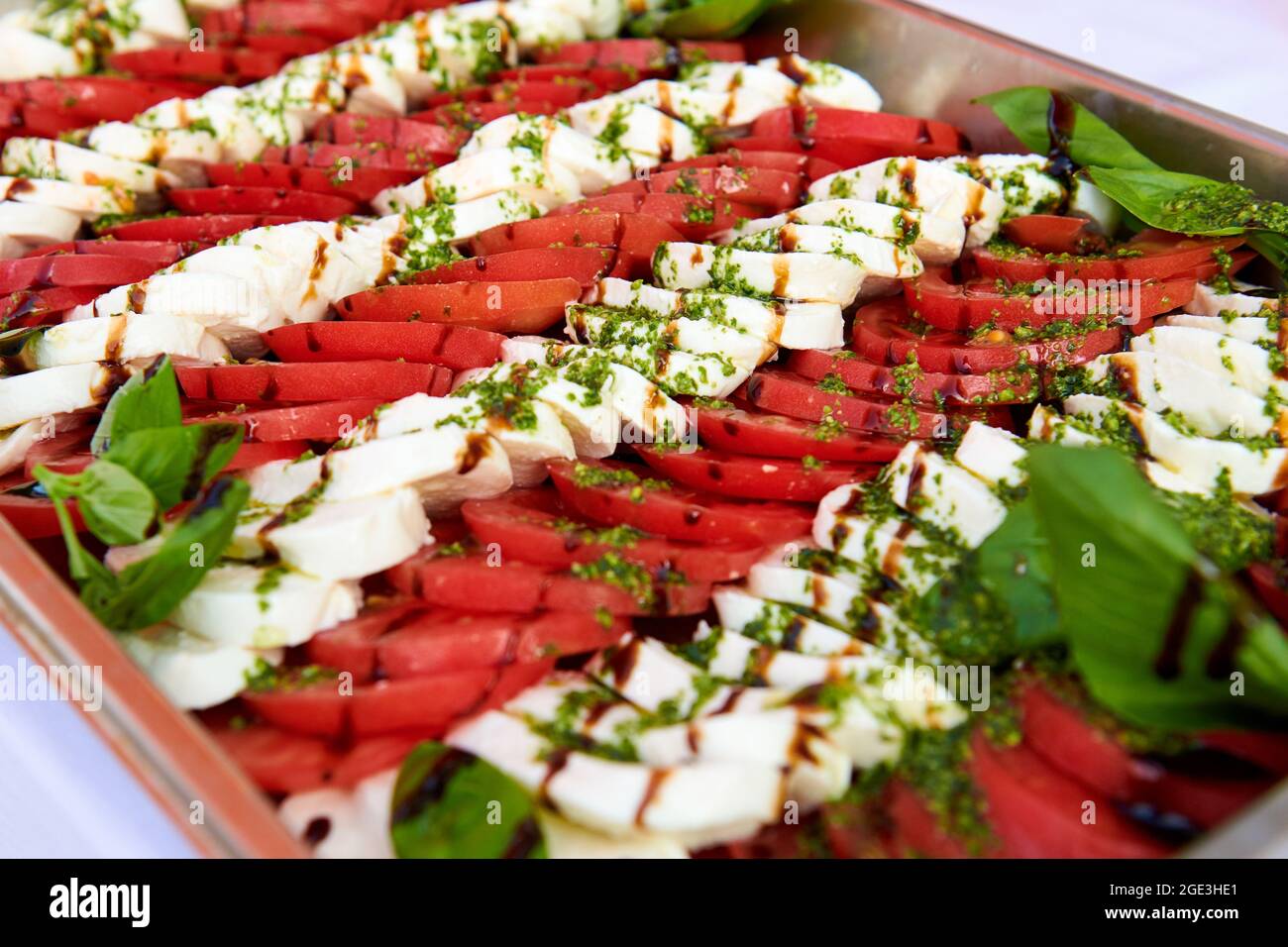 Salade Caprese sur un plateau métallique BEAUCOUP de tomates en tranches et de fromage mozzarella recouvert de sauce pesto. Photo de concept de mode de vie sain. Banque D'Images