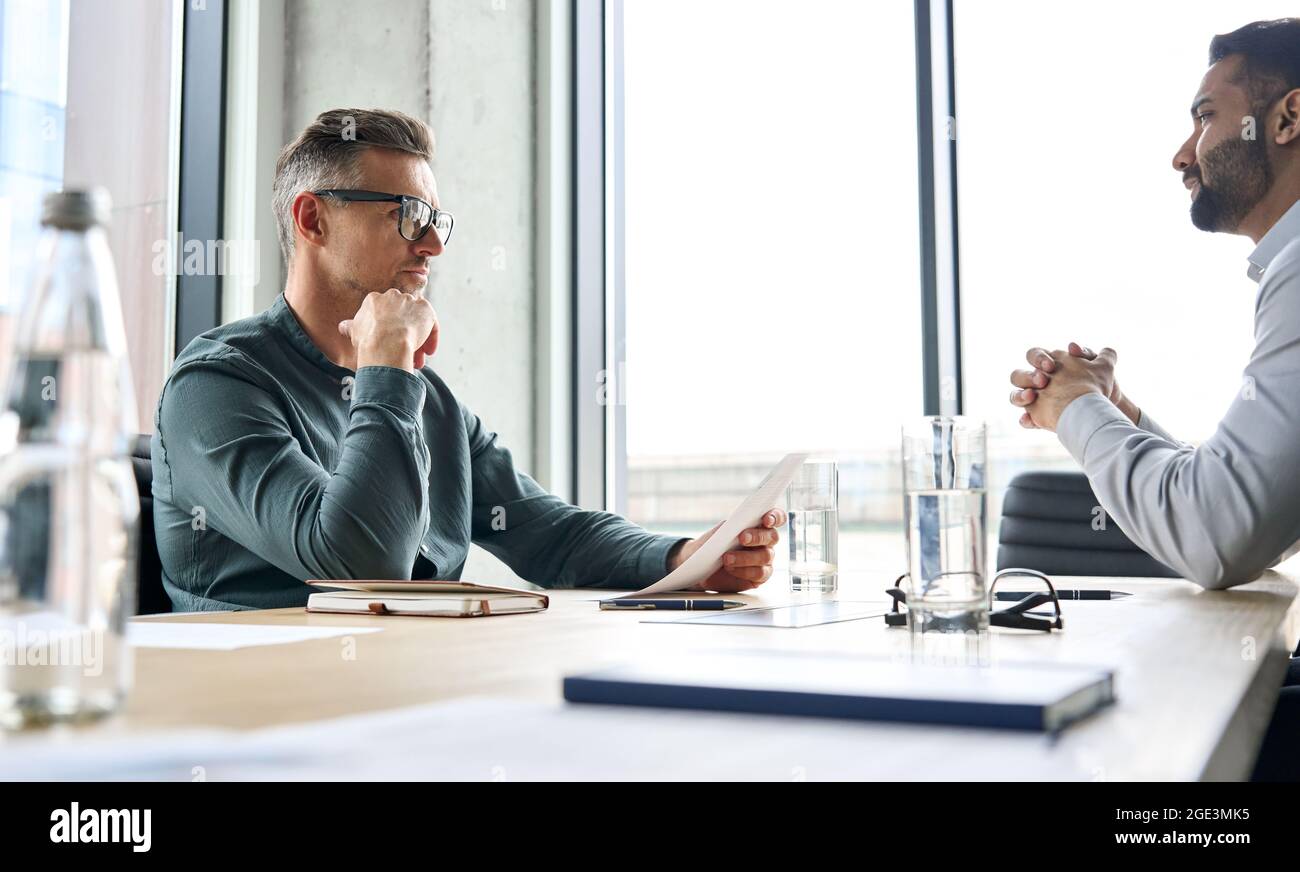 Homme d'affaires sérieux employeur hr tenant cv à l'écoute candidat à l'entrevue d'emploi. Banque D'Images