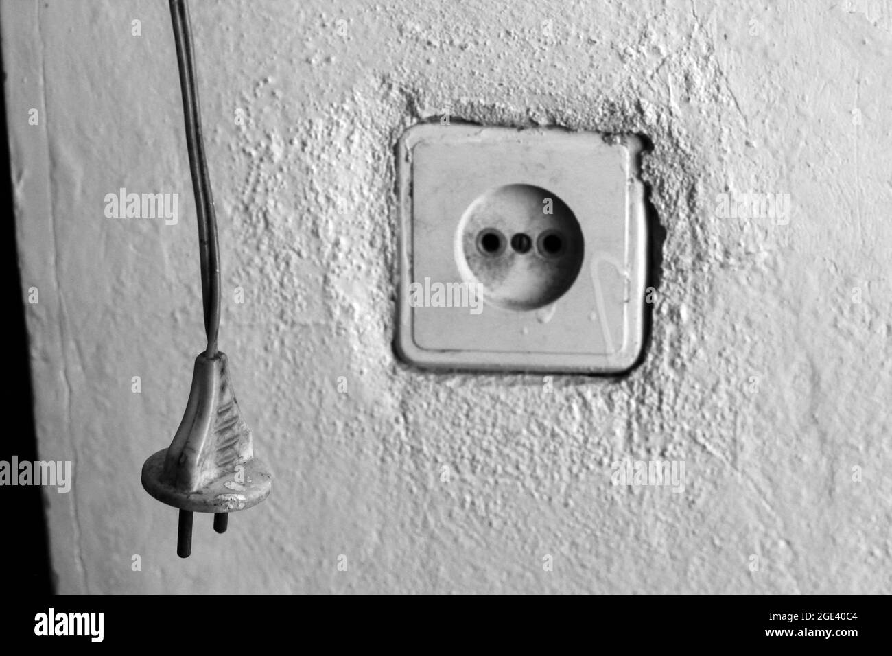 Prise.Réparation à la maison.Câblage électrique.Prise.Fils.Murs plâtrés.Rosace rétro Banque D'Images