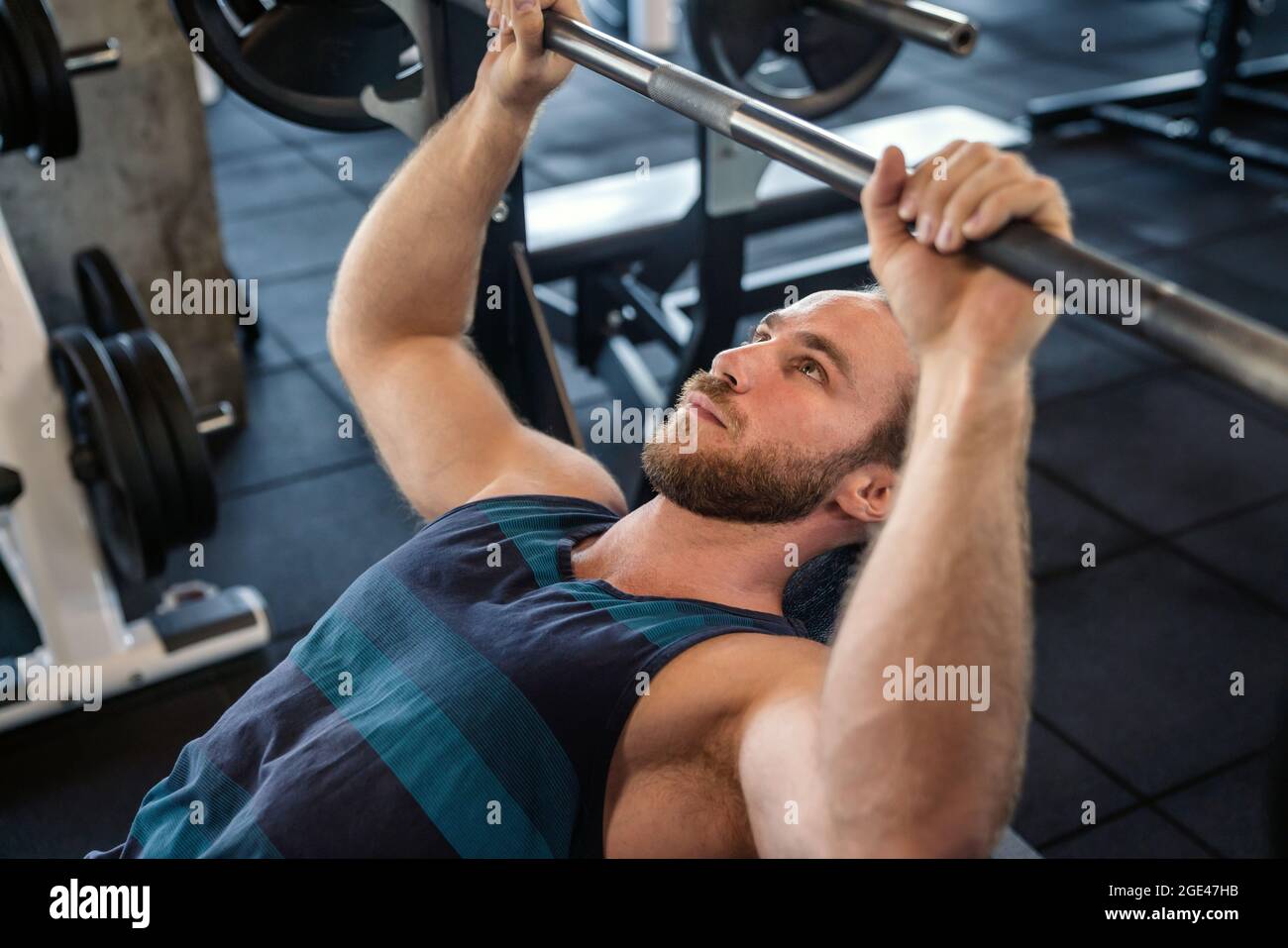 Beau musclé homme travaillant sur disque at gym Banque D'Images