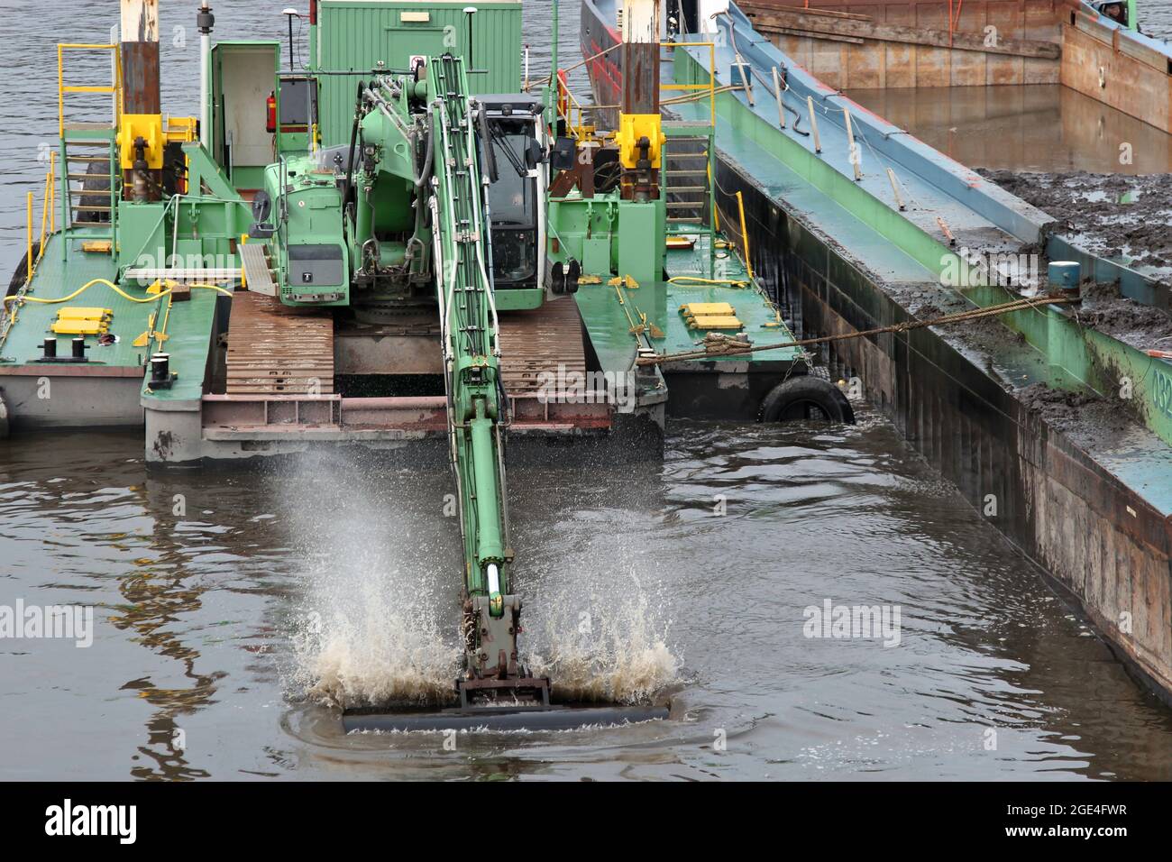 excavatrice sur chenilles sur ponton flottant approfondissant le fairway sur une rivière Banque D'Images