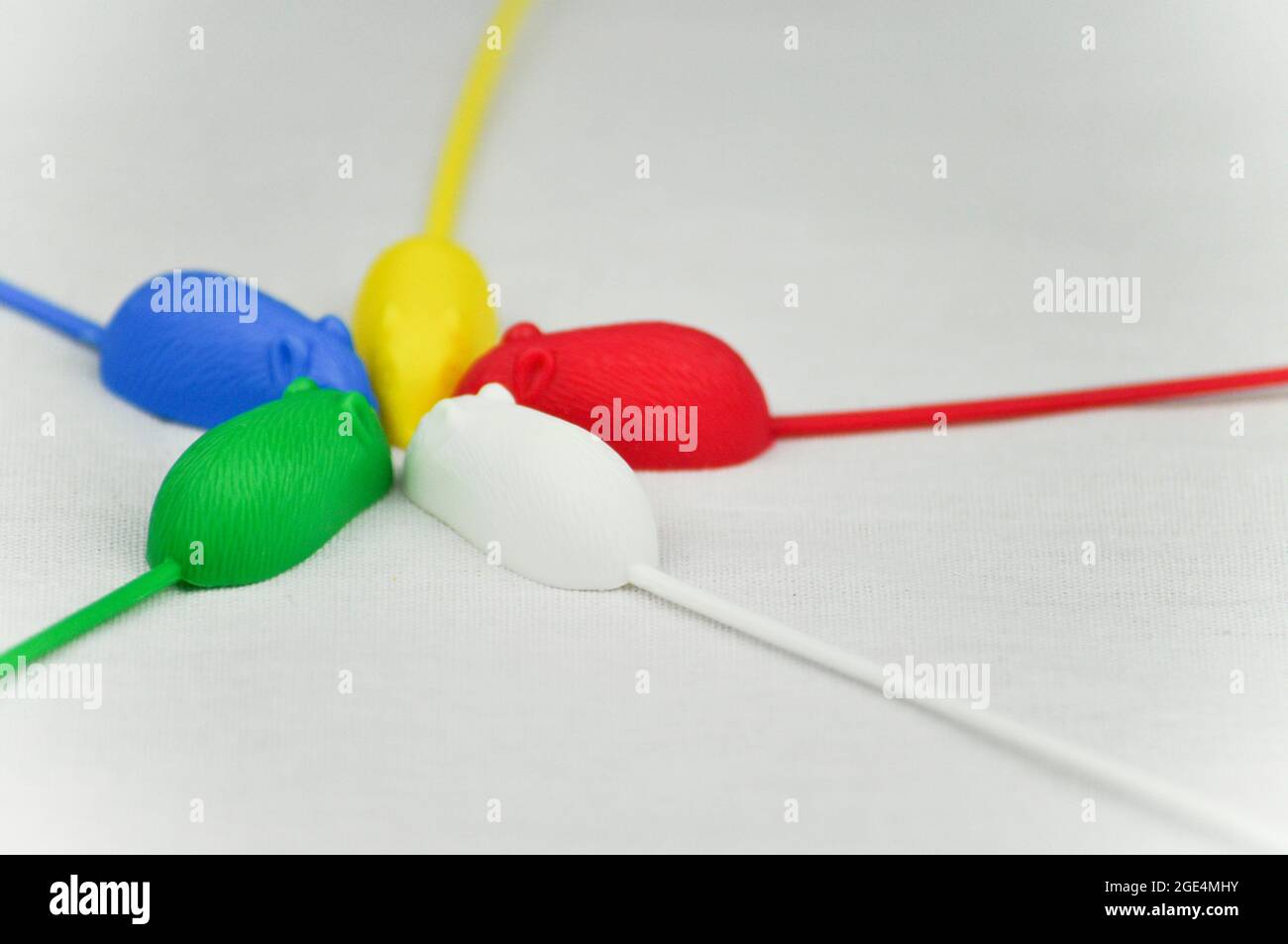 5 souris en plastique avec des queues très longues du jeu rétro, 'Mousie' (également connu sous le nom de 'catch 'em if you CAN').Les souris sont fixées contre un dos blanc Banque D'Images