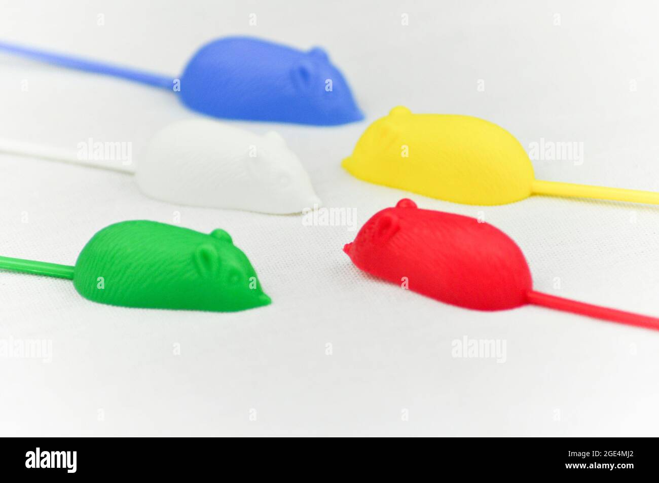 5 souris en plastique avec des queues très longues du jeu rétro, 'Mousie' (également connu sous le nom de 'catch 'em if you CAN').Les souris sont fixées contre un dos blanc Banque D'Images
