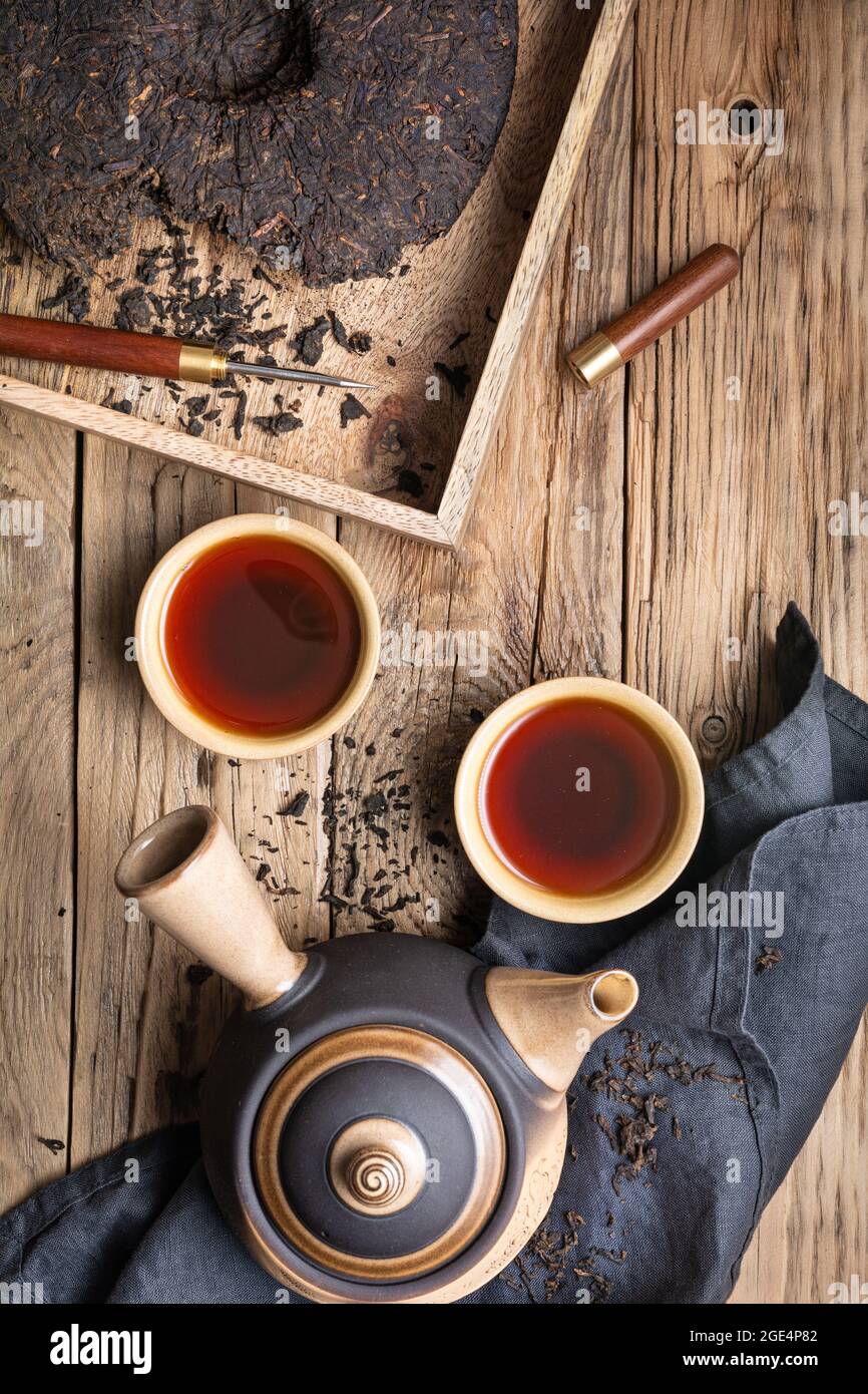 Thé pu-erh médicinal dans des tasses en céramique sur fond de bois Banque D'Images